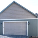 detached garage with white door, mountain fern siding, and GAF shingles