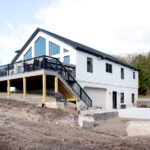 back-left view of a home after a renovation and new deck build