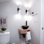 sink, toilet, and wall lughts in bathroom