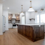 kitchen in a new home with an island, large windows, and white cabients