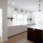 new kicthen with wood island, white cabinets, and shelving