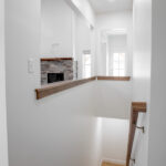 staircase to basement next to living room with gas fireplace