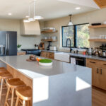 kitchen after home renovation with new island, counters, and shelves