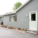 home with new siding and windows with brown shutters