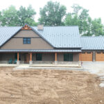 new home with front porch and three garage doors