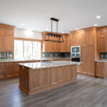 new kitchen with brown cabinets, new appliances, and island