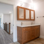 double sink with brown cabinets and medicine cabinet