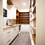 pantry with wooden shelves, sink and microwave