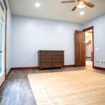room with dresser, bathroom, and door leading to backyard