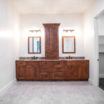 double sink with wooden cabines, square mirrors, and lights