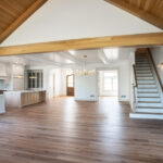 living room with wood ceiling leading to stairs and kitchen