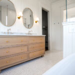 bathroom with double sink and two circle mirrors