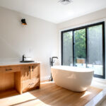 double sink and tub next to large windows