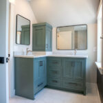 bathroom with two sinks and green cabinets