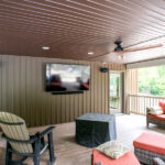 covered porch with seating and a tv