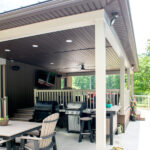 outdoor living space with grills, bar, dining set, and tv space