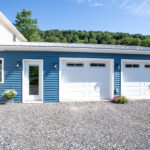 garage addition with two white garage doors
