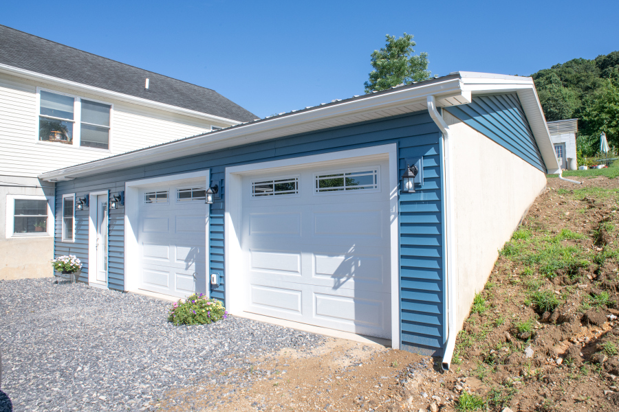 DSC_0143 garage addition with blue siding and two white garage doors