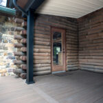 log cabin home with a partially covered deck near new back door