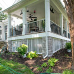 railings, roof, stone veneer, and white lattice on front porch