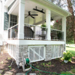 railings, stone veneers, and white lattice on front porch