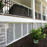 front porch with white lattice at the bottom and black railings on top
