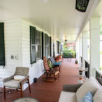 front porch with mahogany wood. rocking chairs, and outdoor sofas