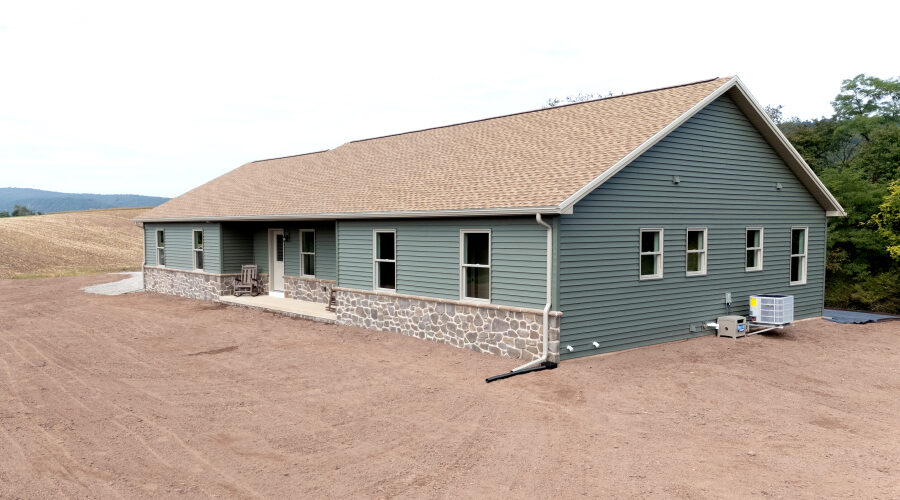 DJI_20261001115005_0028_D new home with green siding and stone veneer