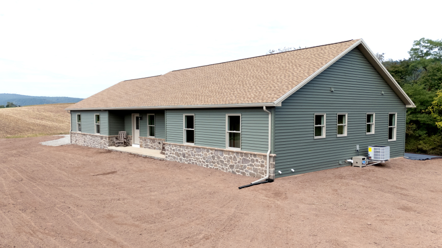 new home with green siding and stone veneer