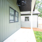 renovated front porch with green siding and chandeleir
