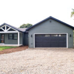 garage addition with gray siding and windows in garage door