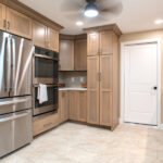 renovated kitchen with new fridge, two ovens, and floor to ceiling cabinets