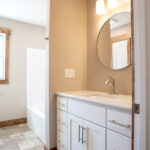 sink with circle mirror and shower in bathroom