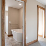 doors to bathroom with large tub